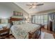 Relaxing primary bedroom with hardwood floors, large window, and a comfortable king-size bed at 14334 W Shawnee Trl, Surprise, AZ 85374