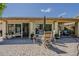 A backyard patio with a table set, umbrella, and chairs create a perfect space for outdoor entertaining at 14334 W Shawnee Trl, Surprise, AZ 85374
