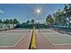 Well-maintained pickleball courts surrounded by trees, and a bright sunny sky at 14334 W Shawnee Trl, Surprise, AZ 85374