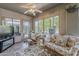 This sun room has plenty of natural light, lots of cozy seating, and views of the pool and backyard at 14334 W Shawnee Trl, Surprise, AZ 85374