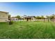Expansive backyard with lush green grass, perimeter fencing and several outbuildings at 1438 E Mesquite St, Gilbert, AZ 85296
