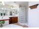 Bathroom with double sinks, wood cabinets, tiled floors, glass block shower, and soaking tub at 1438 E Mesquite St, Gilbert, AZ 85296