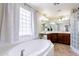 Bathroom with a tub, glass block shower, double sinks, and lots of natural light at 1438 E Mesquite St, Gilbert, AZ 85296