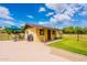 Charming exterior view of a well-maintained guest house with a patio and blue umbrella in a lush yard at 1438 E Mesquite St, Gilbert, AZ 85296