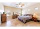 Bedroom featuring a ceiling fan, tan walls, tile floors, and abundant natural light from the windows at 1438 E Mesquite St, Gilbert, AZ 85296