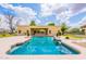 Backyard pool with desert landscaping, sun umbrellas, and an open view of the house at 1438 E Mesquite St, Gilbert, AZ 85296