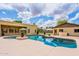 Aerial view of the backyard pool featuring a waterfall, and the home's architecture surrounded by desert landscaping at 1438 E Mesquite St, Gilbert, AZ 85296