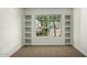 Carpeted bedroom with a large window overlooking the front yard, featuring built-in shelving at 14458 W Zuni Trl, Surprise, AZ 85374