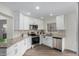 This modern kitchen features stainless steel appliances, granite countertops, and white cabinets at 14458 W Zuni Trl, Surprise, AZ 85374