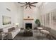Bright living room with fireplace, high ceilings, neutral walls, and shuttered windows at 14458 W Zuni Trl, Surprise, AZ 85374
