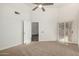 Spacious bedroom featuring plush carpets, modern ceiling fan, and folding doors at 14458 W Zuni Trl, Surprise, AZ 85374
