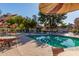 Inviting community pool surrounded by lounge chairs and tables, perfect for relaxation at 14458 W Zuni Trl, Surprise, AZ 85374