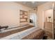 Well-lit bedroom showcasing a large bed, built-in shelves, and a bathroom view at 14950 W Mountain View Blvd # 7309, Surprise, AZ 85374
