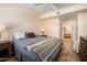 Spacious bedroom featuring warm lighting, hardwood floors, ceiling fan and a view of the bathroom at 14950 W Mountain View Blvd # 7309, Surprise, AZ 85374