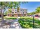 Well-maintained building with lush green lawns, mature trees, and a pathway to the entrance at 14950 W Mountain View Blvd # 7309, Surprise, AZ 85374