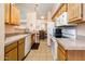 Open kitchen layout with ample counter space, white appliances, and wood cabinets at 14950 W Mountain View Blvd # 7309, Surprise, AZ 85374