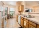 Well-lit kitchen featuring wood cabinets, laminate countertops, and a breakfast nook with a view at 14950 W Mountain View Blvd # 7309, Surprise, AZ 85374