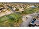 A scenic aerial view of golf course community featuring lush green fairways, mature trees and a tranquil lake at 15109 W Waterford Dr, Surprise, AZ 85374