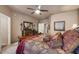 Main bedroom features a ceiling fan, neutral paint, large mirror, and a sitting area at 15109 W Waterford Dr, Surprise, AZ 85374
