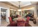 Beautiful dining room features a glass table, red upholstered chairs, and adjacent living area with a piano at 15109 W Waterford Dr, Surprise, AZ 85374