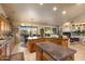 Open-concept kitchen and living area with an island, granite countertops, and a cozy fireplace at 15109 W Waterford Dr, Surprise, AZ 85374