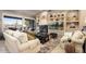 Inviting living room with comfortable seating, built-in shelving, fireplace, and large windows showcasing outdoor views at 15109 W Waterford Dr, Surprise, AZ 85374
