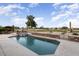 Sparkling pool with stone accents and golf course view in the backyard of this property at 15109 W Waterford Dr, Surprise, AZ 85374