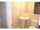 Cozy half-bath with a pedestal sink, toilet, and a framed mirror at 15229 S 18Th Dr, Phoenix, AZ 85045
