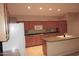 Kitchen with wood cabinetry, a gas cooktop, an island with a sink and tile flooring at 15229 S 18Th Dr, Phoenix, AZ 85045