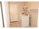 Functional laundry room features a washer, dryer, storage shelf, and tile flooring at 15229 S 18Th Dr, Phoenix, AZ 85045
