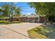Charming brick home featuring a well-manicured lawn, mature trees, and a spacious driveway on a sunny day at 1529 W Rovey Ave, Phoenix, AZ 85015