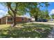 Well-maintained brick house with lush lawn, mature trees, and a welcoming front porch at 1529 W Rovey Ave, Phoenix, AZ 85015