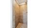 A step-in shower with beige tiled walls and flooring makes for a bright, clean space at 1529 W Rovey Ave, Phoenix, AZ 85015