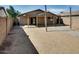 This backyard features a covered patio area, gravel accents and low-maintenance landscaping at 16188 W Boca Raton Rd, Surprise, AZ 85379