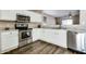 Stylish kitchen with white cabinetry, stainless steel appliances, and wood-look flooring at 16188 W Boca Raton Rd, Surprise, AZ 85379