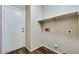 Laundry room with wood-look flooring, storage shelves, and utility connections at 16188 W Boca Raton Rd, Surprise, AZ 85379