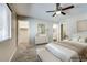 Serene main bedroom with plush carpet, ceiling fan, and ensuite bathroom access at 16188 W Boca Raton Rd, Surprise, AZ 85379