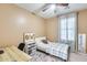 Neutral bedroom featuring a twin bed, desk, a ceiling fan, and light filtering through the window at 1633 W Lacewood Pl, Phoenix, AZ 85045