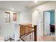 Hallway shows an arched doorway and wooden railing in a home with neutral paint, carpet flooring and recessed lights at 1633 W Lacewood Pl, Phoenix, AZ 85045