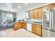 Functional kitchen features wood cabinets, stainless steel appliances, and a view into the dining area at 1633 W Lacewood Pl, Phoenix, AZ 85045