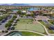Aerial view of a putting green, tennis courts, lake, and clubhouse at 20627 N Lemon Drop Dr, Maricopa, AZ 85138