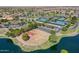 Aerial view of a basketball court with mature trees surrounded by a lake at 20627 N Lemon Drop Dr, Maricopa, AZ 85138