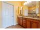 Bathroom featuring dual sinks, granite countertops, and tiled backsplash at 20627 N Lemon Drop Dr, Maricopa, AZ 85138