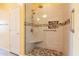 Walk-in shower features decorative stone accents, neutral tile, and grab bars for easy accessibility at 20627 N Lemon Drop Dr, Maricopa, AZ 85138