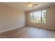 Bright bedroom with luxury vinyl flooring, a ceiling fan, and a scenic window view at 20627 N Lemon Drop Dr, Maricopa, AZ 85138