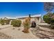View of the home's gravel backyard with privacy shrubs and patio at 215 N Power Rd # 340, Mesa, AZ 85205