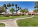 Beautiful clubhouse with a red tile roof surrounded by green lawns and palm trees at 215 N Power Rd # 340, Mesa, AZ 85205