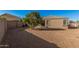 The gravel backyard includes block wall fencing, low-maintenance landscaping and a covered patio at 23805 W Romley Ave, Buckeye, AZ 85326
