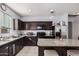 Open kitchen with dark cabinets and stainless appliances at 23805 W Romley Ave, Buckeye, AZ 85326