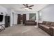Comfortable living area featuring a ceiling fan, neutral carpeting, and a sliding glass door to the backyard at 23805 W Romley Ave, Buckeye, AZ 85326